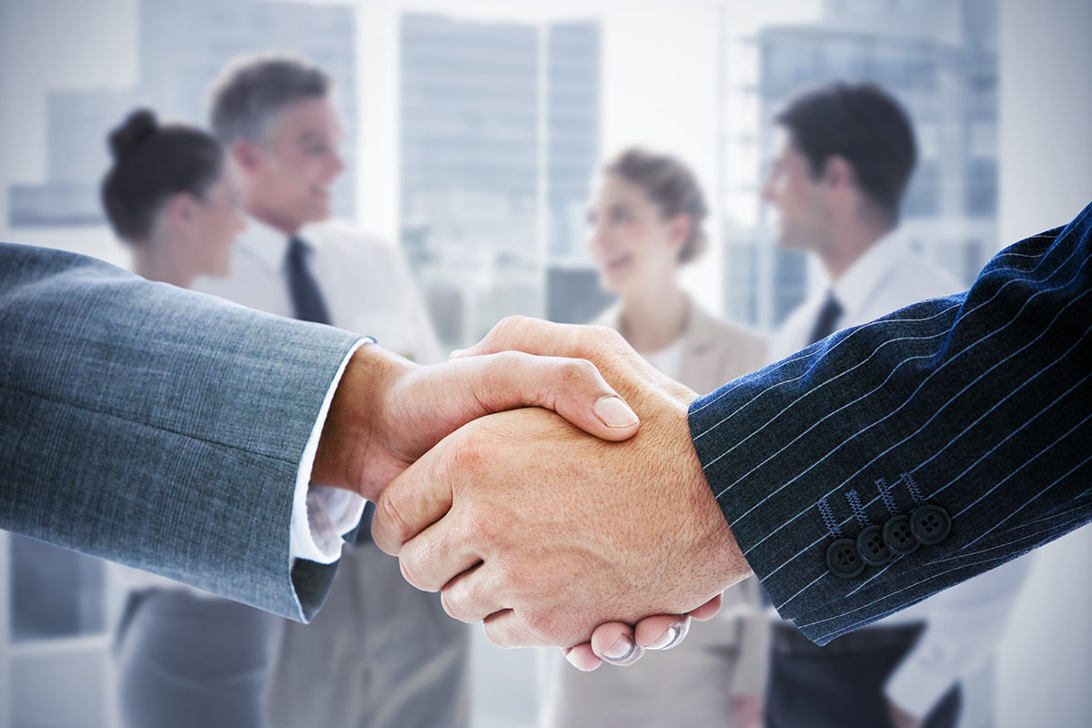 Composite image of business people shaking hands.