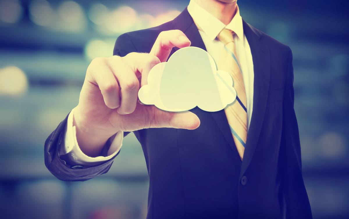 A businessman holding a digital cloud between his thumb and pointer finger