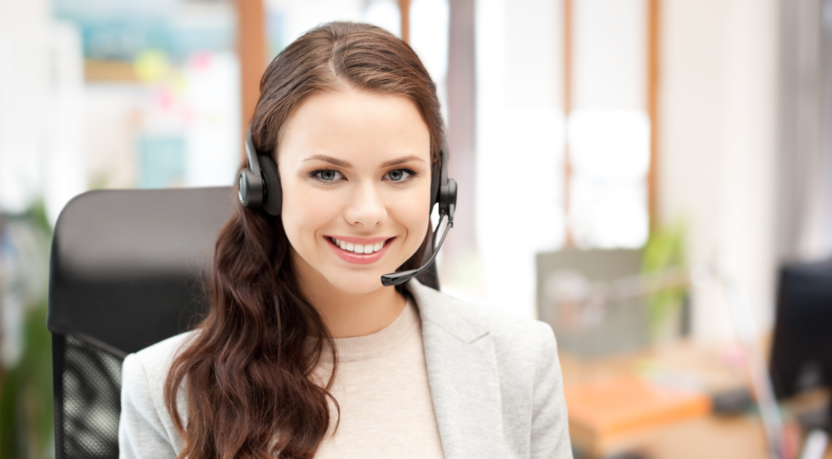 A smiling help desk employee wearing a headset