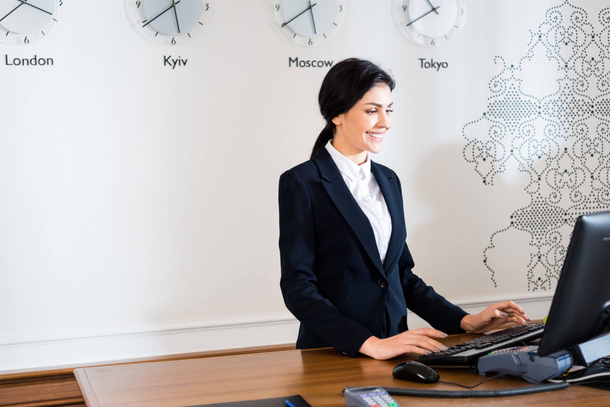 Smiling receptionist working on computer