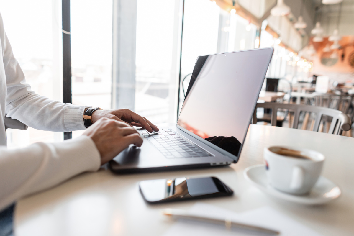 A person working on their laptop in a coffee shop