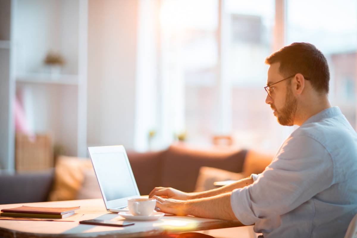 A man working from home using a laptop at a table