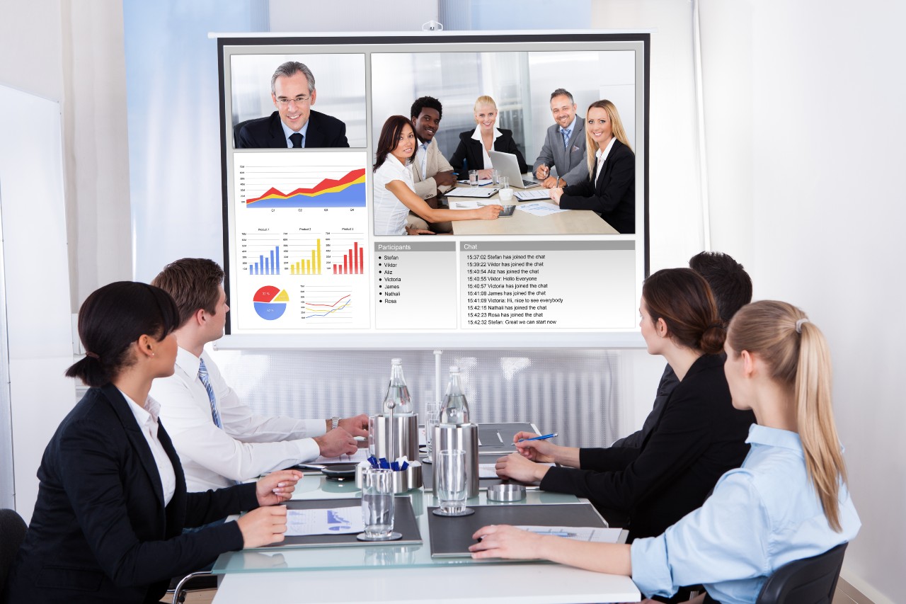 Two groups of business people participating in a video conference