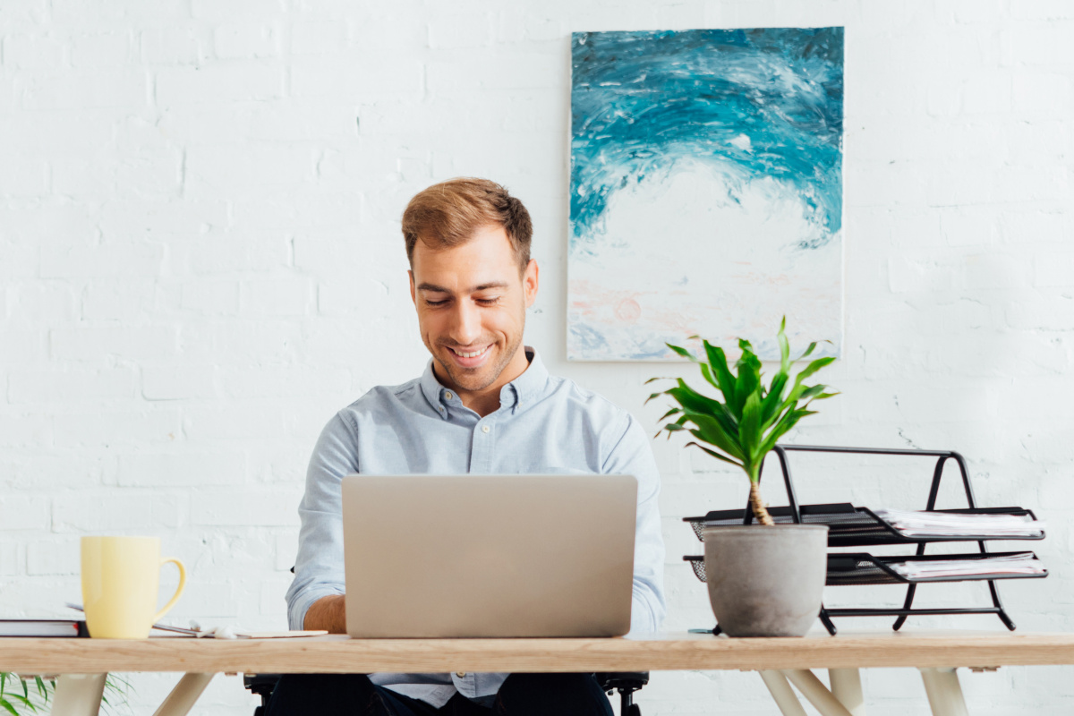 Smiling man working on laptop